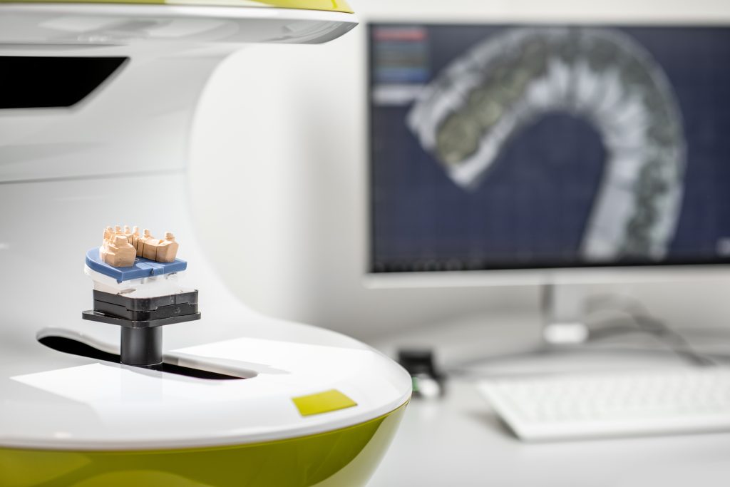 Manufacture of dentures or implants, computer with imprints on the background